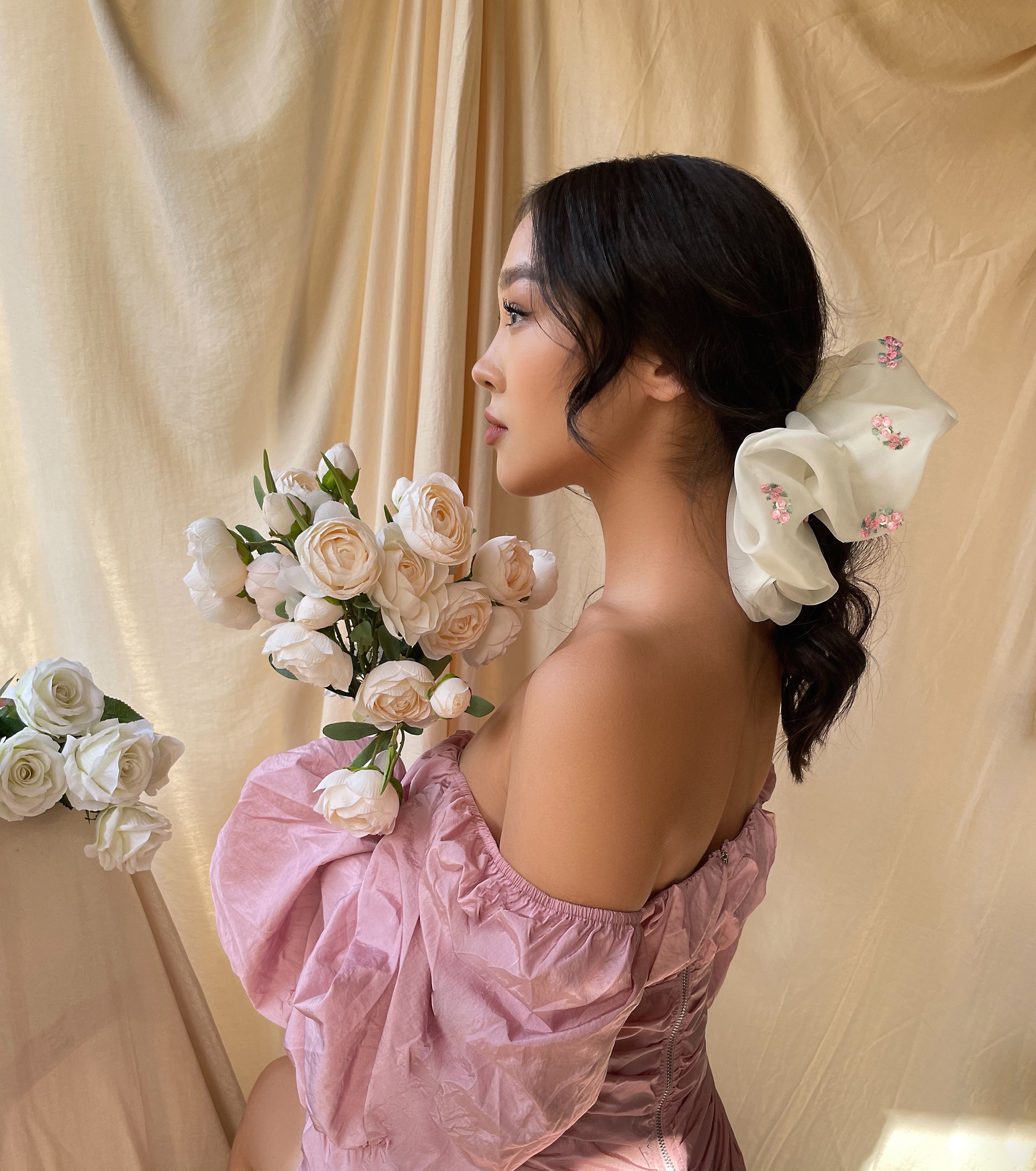 Woman holding flowers and wearing an organza scrunchies with flowers
