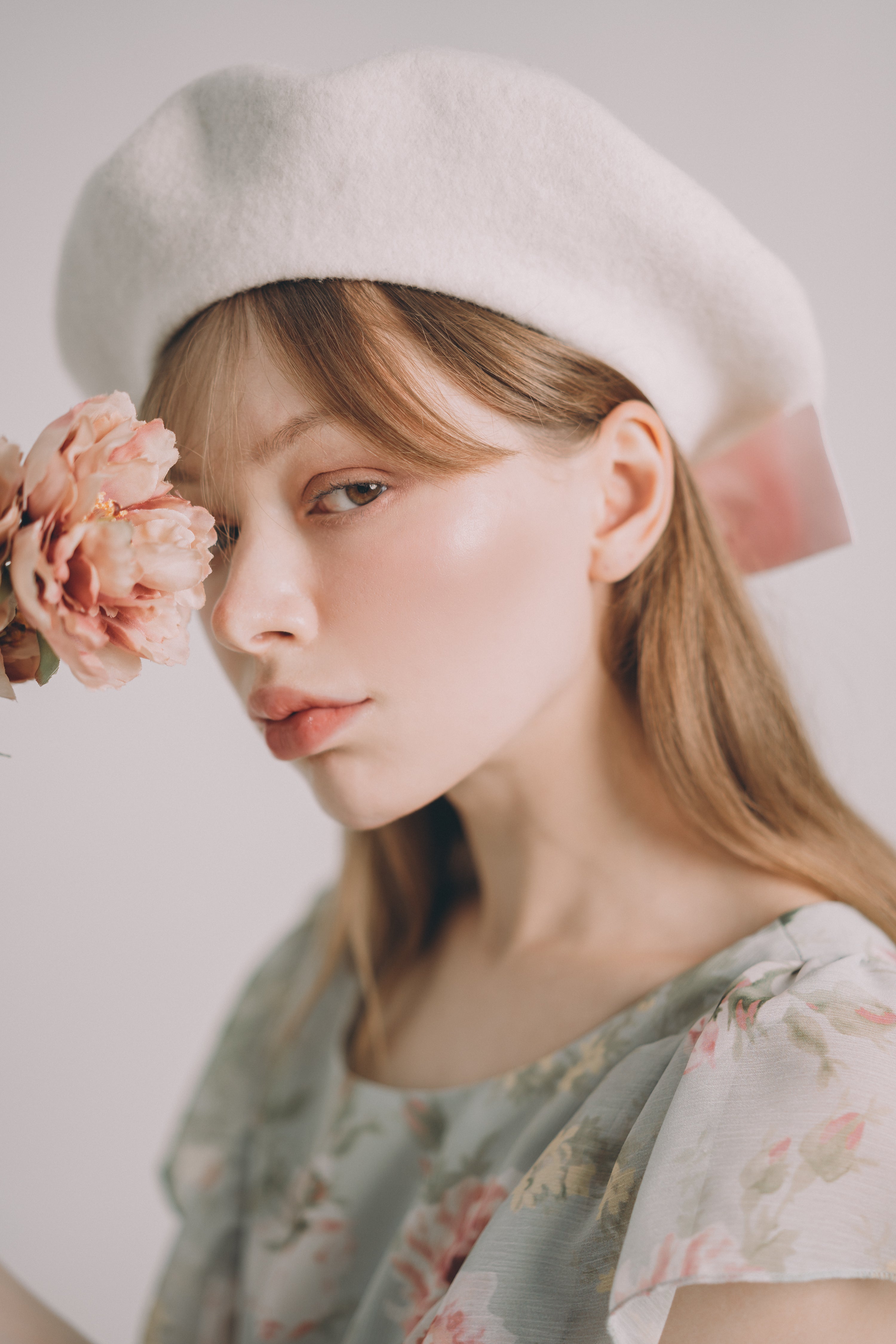Woman wearing a white beret with a soft focus background